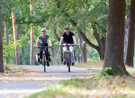 Zwei Radfahrende auf ländlichem Radweg